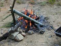 お酒はこうして節を抜いた竹を焚き火に入れ、燗をしました。